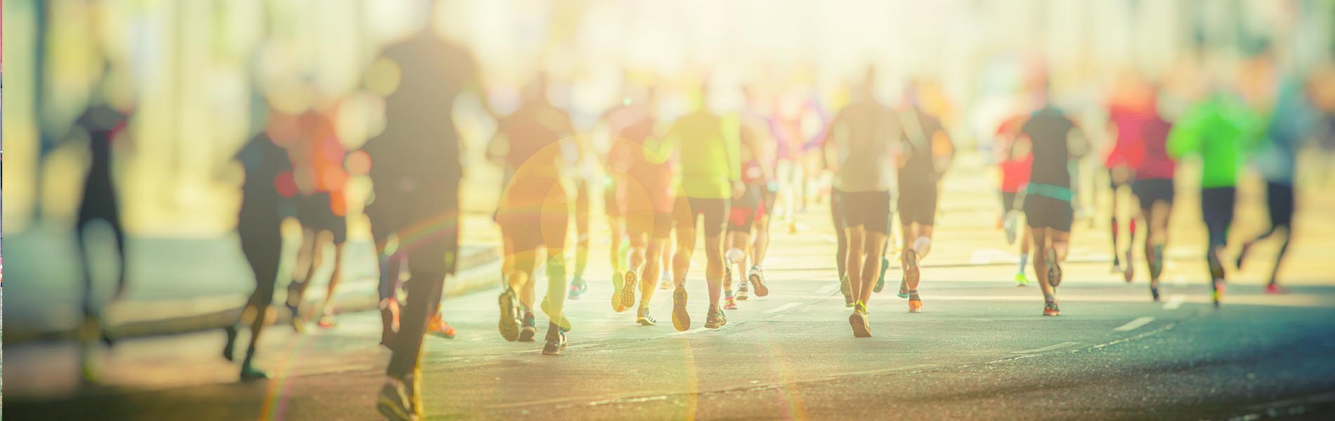 The image depicts a group of people running on a street during the daytime.