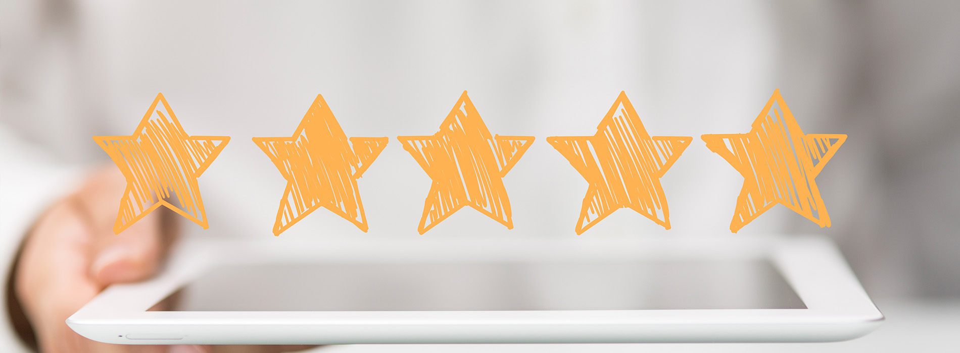 The image shows a hand holding a tablet with a graphic of three yellow stars on top, suggesting a positive rating or review system.