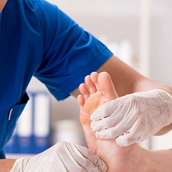 A medical professional applying a bandage to someone s foot.